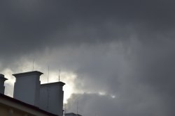 Zdjęcie: zachmurzone niebo, dach z kominem. 