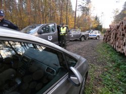 Na zdjęciu: funkcjonariusze przy samochodach patrolują lasy. 